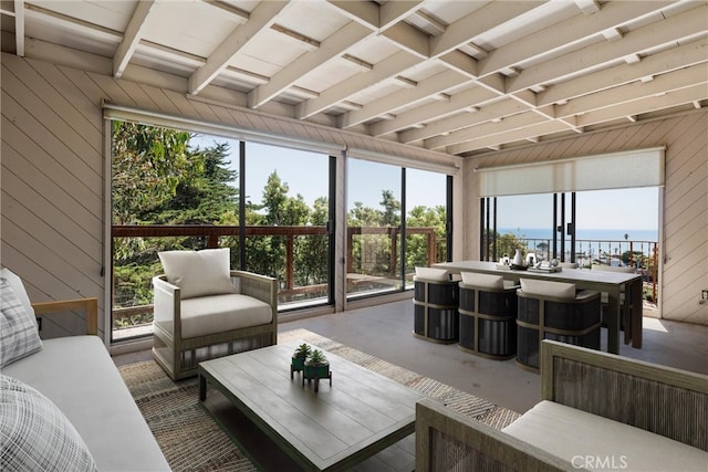 sunroom featuring a water view