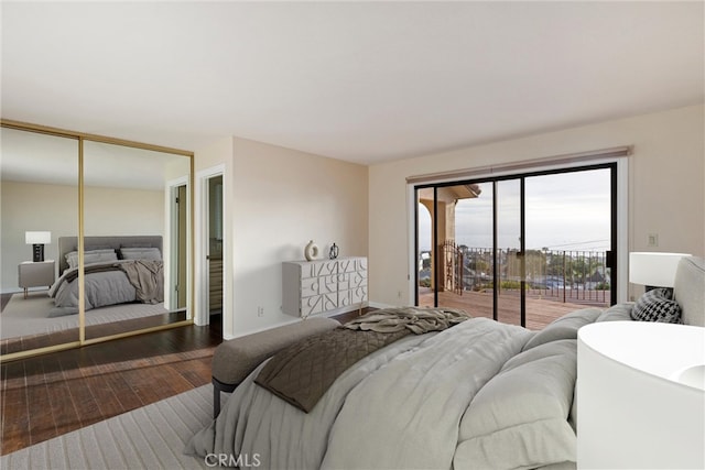 bedroom featuring dark wood-type flooring, access to outside, and a closet