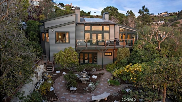 2335 Hillview Dr, Laguna Beach, CA 92651 - back of property featuring french doors, roof mounted solar panels, and a chimney