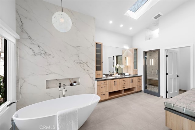 2335 Hillview Dr, Laguna Beach, CA 92651 - bathroom featuring vanity, a skylight, a high ceiling, a soaking tub, and recessed lighting
