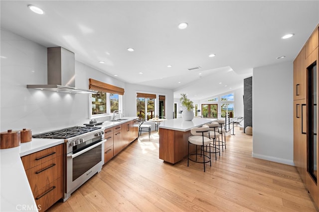 2335 Hillview Dr, Laguna Beach, CA 92651 - kitchen featuring stainless steel range, wall chimney range hood, modern cabinets, a kitchen bar, and recessed lighting