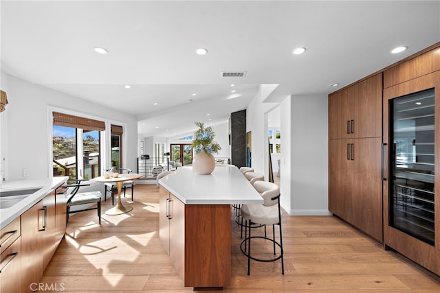2335 Hillview Dr, Laguna Beach, CA 92651 - kitchen with a breakfast bar, modern cabinets, open floor plan, light wood-style flooring, and recessed lighting