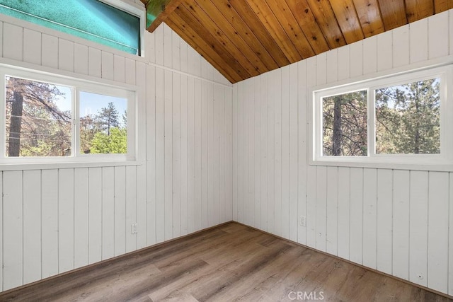 spare room with wood ceiling, hardwood / wood-style flooring, vaulted ceiling, and wood walls