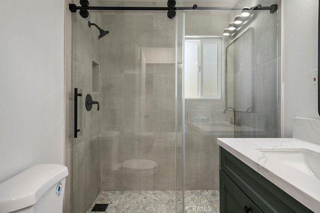 bathroom featuring walk in shower, vanity, and toilet