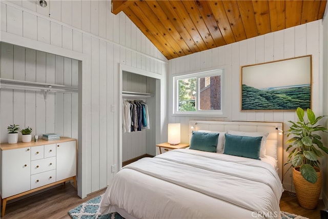 bedroom featuring lofted ceiling, dark wood-type flooring, wooden ceiling, and a closet