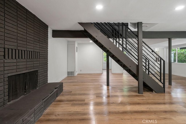 interior space featuring a brick fireplace and light hardwood / wood-style flooring