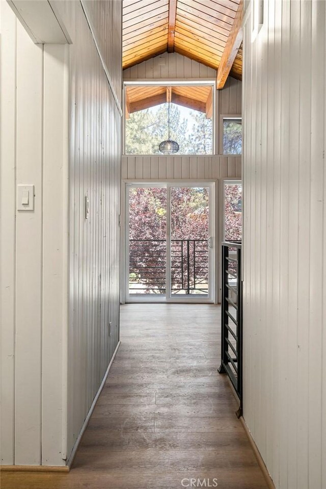 corridor featuring wood ceiling, hardwood / wood-style floors, beam ceiling, wooden walls, and high vaulted ceiling