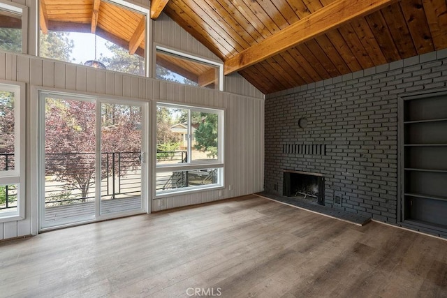 unfurnished living room featuring beam ceiling, a fireplace, light hardwood / wood-style floors, and wooden ceiling