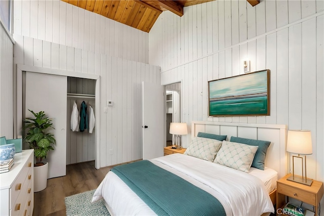 bedroom with wood ceiling, hardwood / wood-style flooring, high vaulted ceiling, a closet, and beamed ceiling