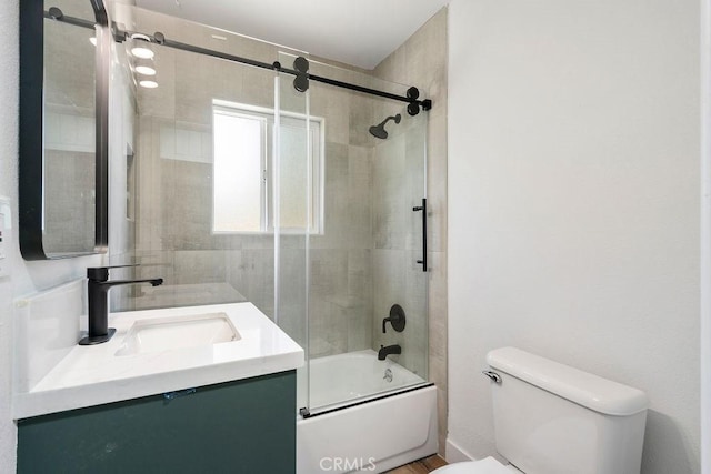 full bathroom featuring bath / shower combo with glass door, vanity, and toilet