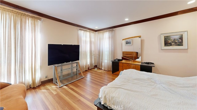 bedroom with ornamental molding and light hardwood / wood-style floors