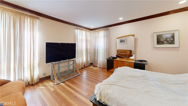 bedroom with ornamental molding and light hardwood / wood-style flooring