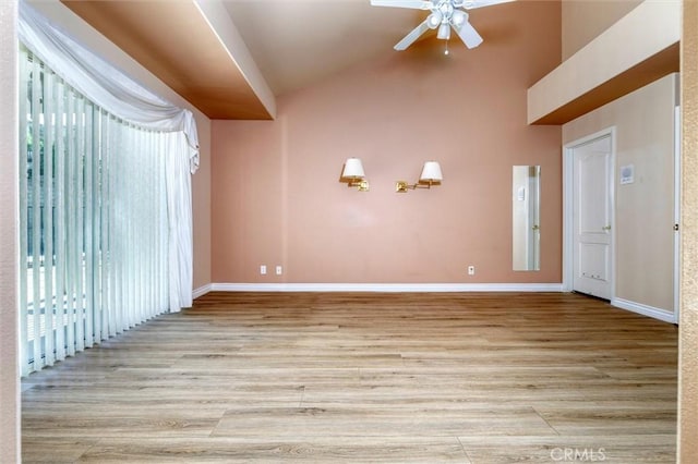 interior space featuring ceiling fan, vaulted ceiling, and light wood-type flooring