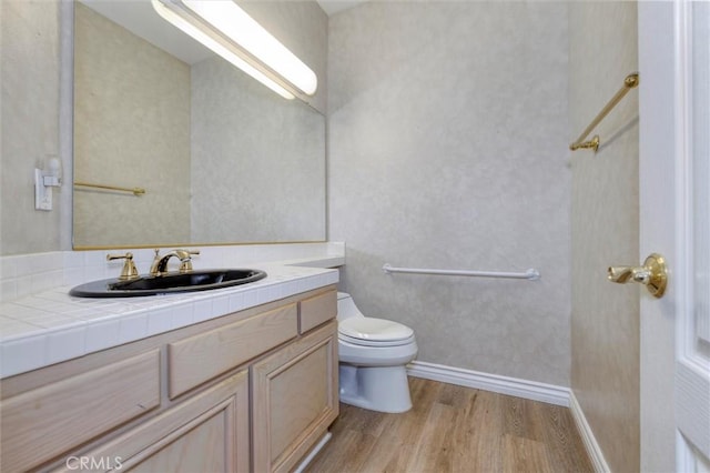 bathroom featuring vanity, hardwood / wood-style flooring, and toilet