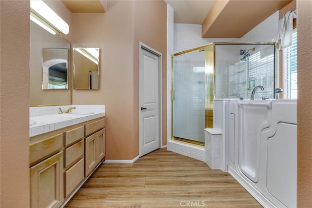 bathroom with vanity, washer / dryer, wood-type flooring, and a shower with shower door