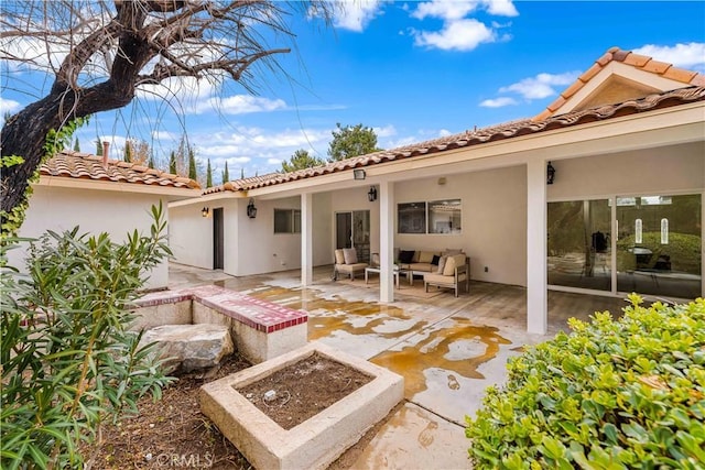 back of property with outdoor lounge area and a patio