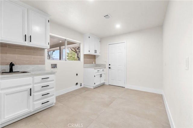 washroom featuring hookup for a washing machine, electric dryer hookup, sink, and cabinets