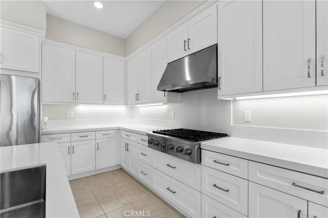 kitchen with appliances with stainless steel finishes, light tile patterned floors, and white cabinets