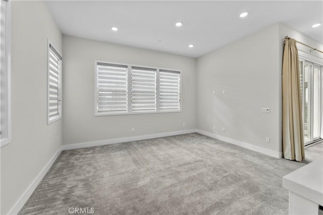 unfurnished room featuring light carpet