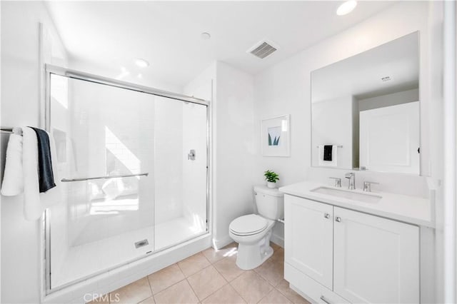 bathroom with tile patterned floors, toilet, vanity, and a shower with shower door