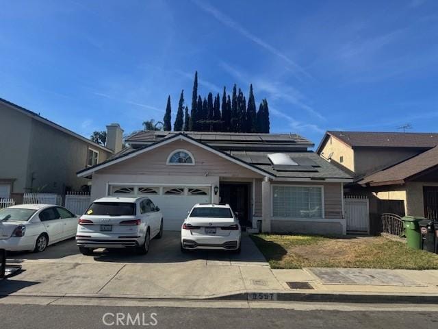 view of front of property with a garage and solar panels