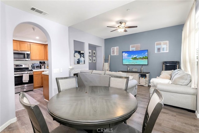 dining space featuring ceiling fan and light wood-type flooring