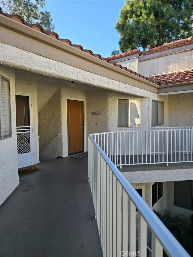 view of exterior entry with a balcony