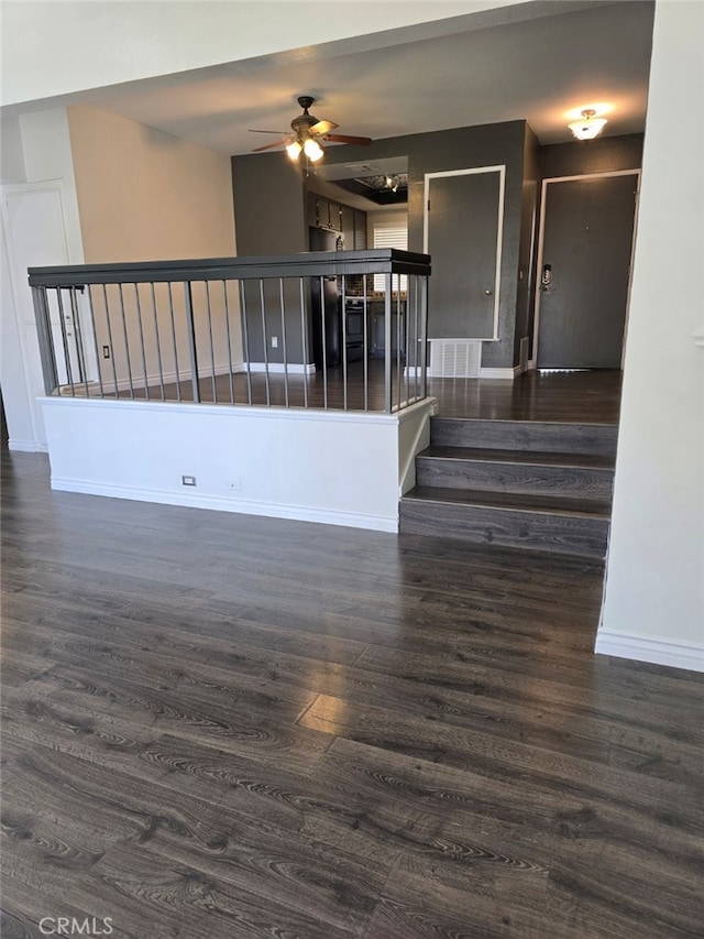 unfurnished room featuring dark wood-type flooring and ceiling fan