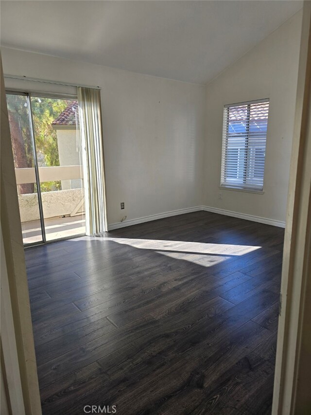 empty room featuring dark hardwood / wood-style flooring and vaulted ceiling