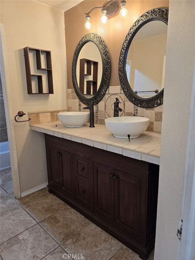 bathroom featuring tasteful backsplash, vanity, a tub, and tile patterned floors