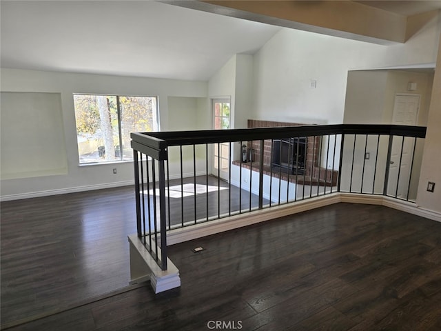 hallway with vaulted ceiling and dark hardwood / wood-style floors