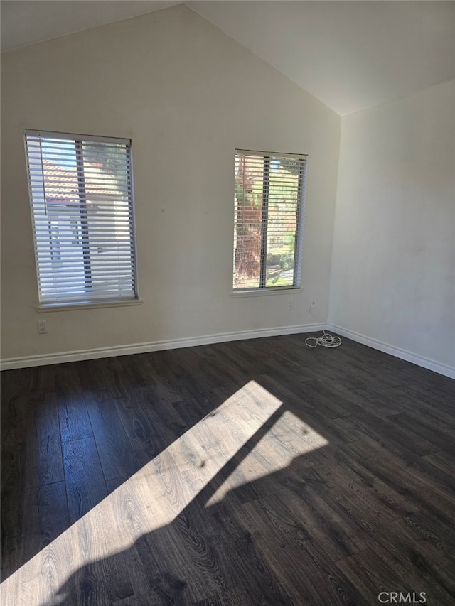 unfurnished room featuring dark wood-type flooring, plenty of natural light, and vaulted ceiling