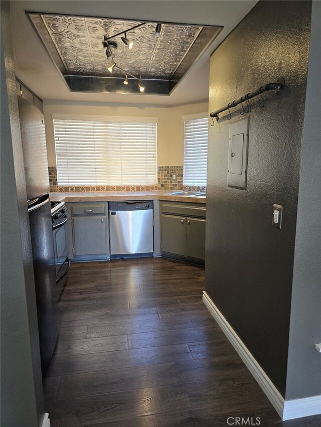 kitchen with dark hardwood / wood-style floors, tasteful backsplash, a tray ceiling, stainless steel dishwasher, and white gas stove