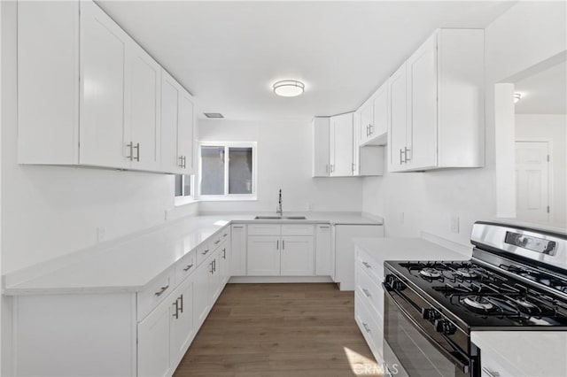 kitchen with white cabinetry, sink, dark wood-type flooring, and stainless steel gas range