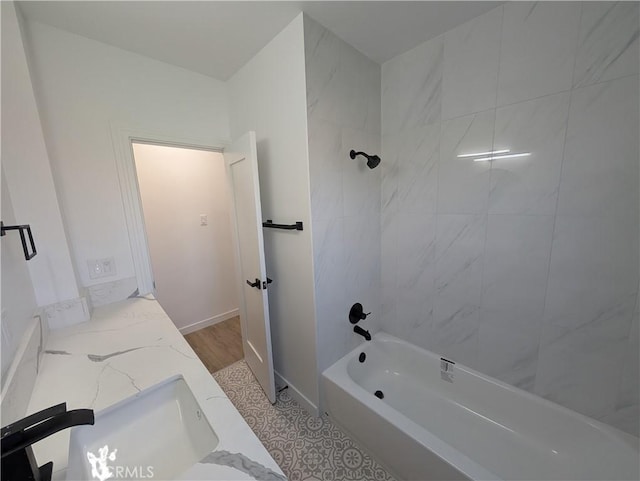 bathroom featuring tiled shower / bath combo and vanity