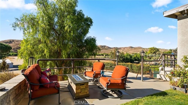 view of patio / terrace featuring a mountain view and a fire pit