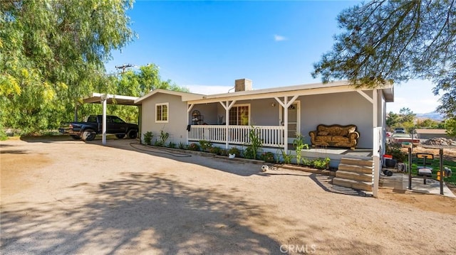 ranch-style home featuring a porch and a carport