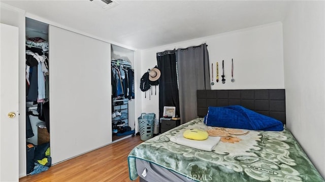 bedroom with wood-type flooring and a closet