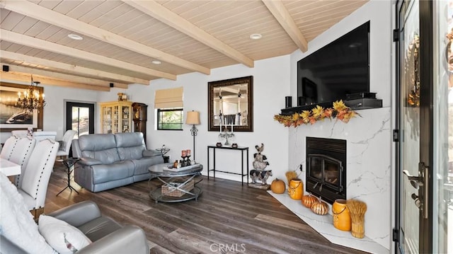 living room with hardwood / wood-style flooring, a premium fireplace, an inviting chandelier, wooden ceiling, and beamed ceiling