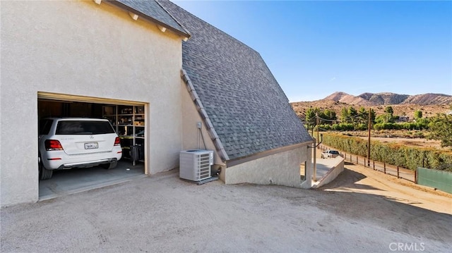 view of side of property featuring a mountain view and central AC unit