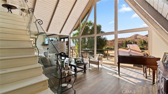 sunroom / solarium featuring a mountain view, wood ceiling, and vaulted ceiling with beams