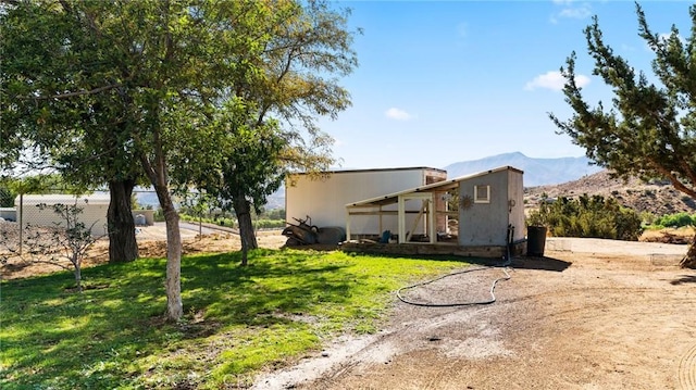 view of property exterior featuring a mountain view and a yard