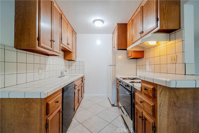 kitchen with sink, light tile patterned floors, dishwasher, tasteful backsplash, and white gas range