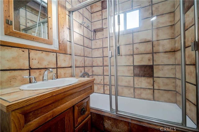 bathroom with vanity, combined bath / shower with glass door, and decorative backsplash