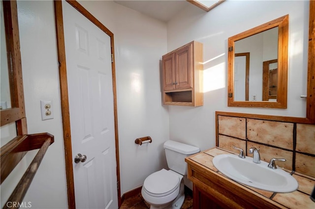 bathroom with tasteful backsplash, vanity, and toilet