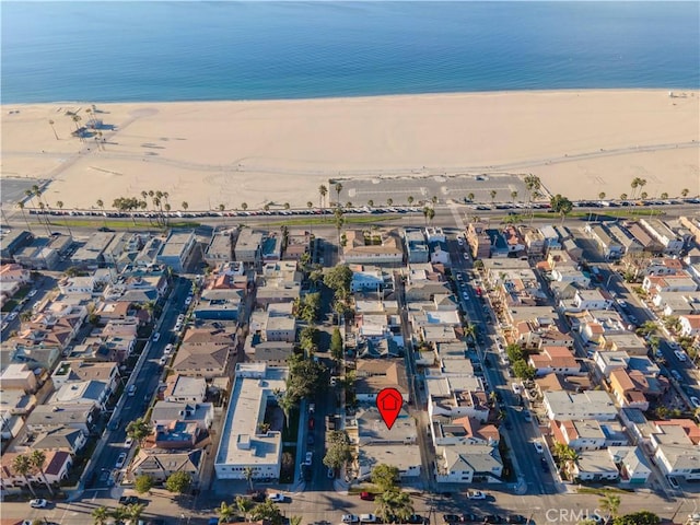 drone / aerial view featuring a beach view and a water view