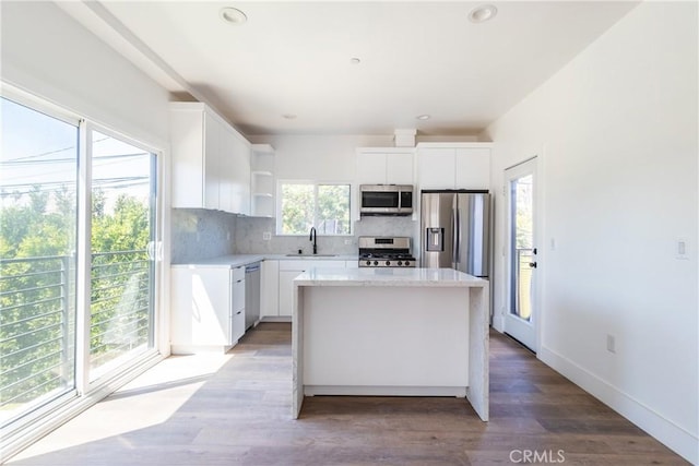 kitchen featuring appliances with stainless steel finishes, a center island, sink, and white cabinets