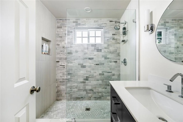 bathroom with vanity and a tile shower