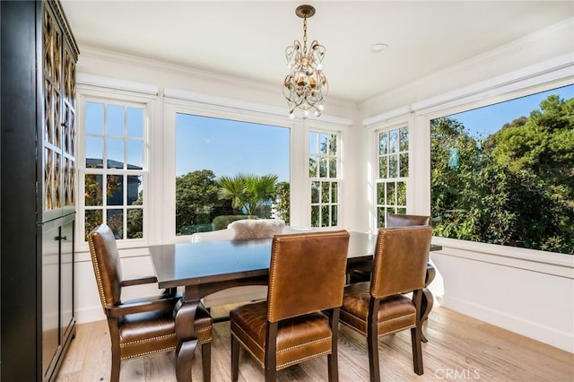 sunroom / solarium featuring a chandelier