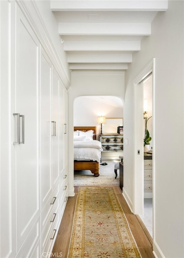 bedroom featuring beamed ceiling and hardwood / wood-style floors